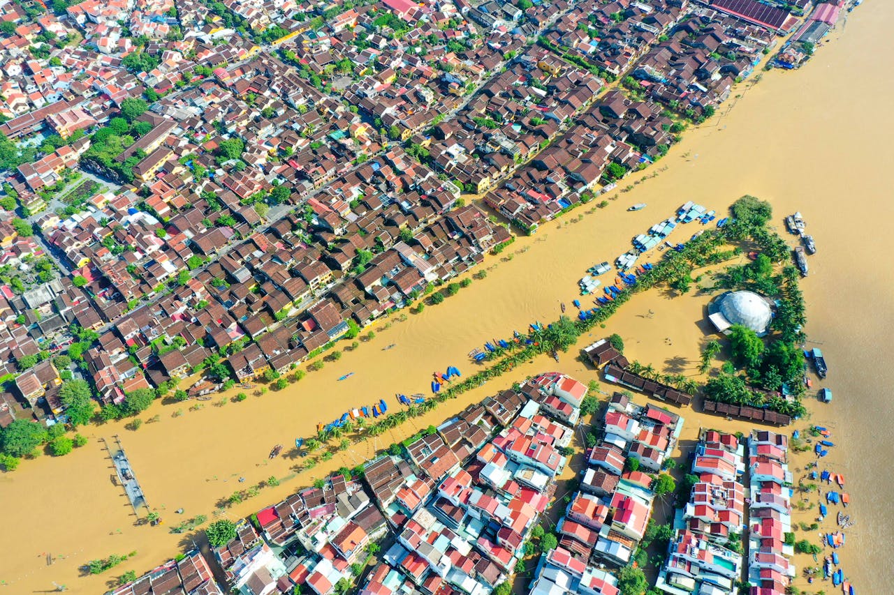 Home A striking aerial view of floodwaters in Hội An, Việt Nam, showcasing the citys streets and buildings submerged.